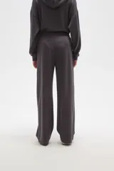 Pantalon de corte ancho y tiro medio, confeccionado en tejido de poliester, con cintura elastizada y costura central vertical en el frente.