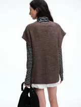 Chaleco de tejido de punto con lana y alpaca, de corte relajado y caída recta. Presenta laterales abiertos con cierre de botones y cuello redondo.