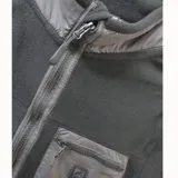 Campera de polar negro con cierre frontal completo, cuello alto y bolsillo en el pecho con cierre y detalle de logo. Cuenta con dos bolsillos laterales con cierre.