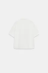 Camisa azul de manga corta y cuello solapa con costura horizontal en el pecho y cierre frontal oculto con botones.