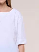 Blusa de algodón blanca, de manga corta amplia, con tajo en el ruedo lateral decorado con tres botones.