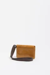 Billetera compacta de cuero color marrón con acabado brillante, cierre de solapa y cordón ajustable de tela marrón con terminales metálicos. Incluye el logo de la marca grabado en la parte frontal.