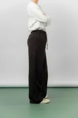 Pantalón de corte relajado y pierna recta, confeccionado en tejido tipo corderoy liviano. Presenta cintura elastizada con cordón ajustable y diseño de silueta amplia.