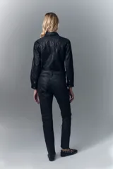 Pantalón de jean con calce skinny y tiro alto, confeccionado en denim negro con un proceso de coating marrón que le otorga una apariencia similar al cuero y un diseño de animal print realizado con láser.