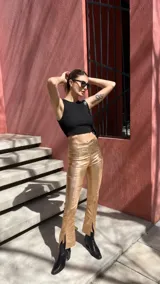 Pantalón negro de tiro alto, corte ajustado y confeccionado en gabardina elastizada con acabado metalizado.