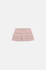 Shorts mini de tiro medio con cintura elástica ajustable mediante cordones. Presenta un diseño de múltiples volantes escalonados con detalles de encaje a tono.