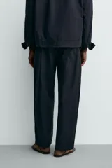 Pantalón straight fit color negro, confeccionado en popelín de algodón, con cintura elástica y bolsillos frontales.