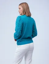 Buzo de tejido de hilado fino color celeste, marca Zac & Rachel. Mangas largas de gasa con bordado desflecado.