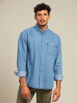 Camisa celeste de manga larga con cuello abotonado y bolsillo en el pecho.