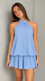 Vestido corto celeste de diseño holgado, con cuello halter fruncido y falda con volados.
