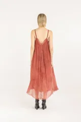 Vestido midi lencero de viscosa y seda, color salmón, con breteles regulables, escote en V, silueta evasé con vuelo, bolsillos laterales y ruedo deshilachado.