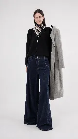 Pantalón de pana de algodón con tiro medio y corte de pierna ancha. Presenta dos bolsillos delanteros y dos traseros con detalles de pespuntes.