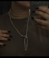 Collar plateado de strass con doble cadena, una tipo gargantilla y otra más larga con terminaciones metálicas.