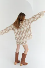 Sweater oversize con cuello en V y estampado de rombos en tonos lila, rosa y rojo. Tejido de lana artesanal.