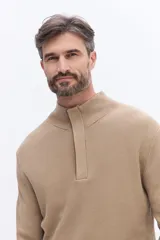 Buzo de tejido acanalado con cuello alto y apertura frontal con cierre, de calce cómodo y estructura limpia.