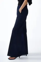 Jean de denim azul oscuro con tiro alto y corte acampanado, confeccionado con algodón elástico. Presenta bolsillos laterales al bies y cierre frontal oculto.
