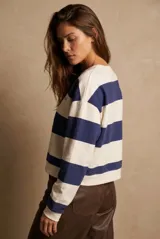 Sweater de algodón a rayas horizontales en color blanco y azul marino, con cuello redondo, manga larga y el texto bordado "The Creative Club URUGUAY" en el frente.