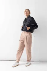 Chaqueta bomber negra con cierre frontal de botones a presión y bolsillos laterales.