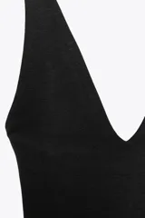Body negro de tejido texturizado, con escote en V pronunciado y tirantes anchos.