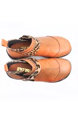 Bota baja estilo botín de cuero color rojo, con hebilla dorada y elástico negro.