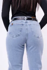 Pantalón de jean estilo mom, de tiro alto y corte recto con ruedos doblados. Presenta un lavado claro y cierre frontal con botón y cremallera.