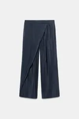 Pantalón de tiro alto con diseño cruzado tipo pareo en el frente, pernera ancha y acabado satinado.