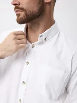 Camisa de corte clásico confeccionada en tejido Oxford de algodón, con cuello abotonado, manga larga y bolsillo frontal en el pecho.