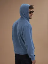 Campera con capucha de toalla color gris claro, con cierre completo y bolsillos frontales.