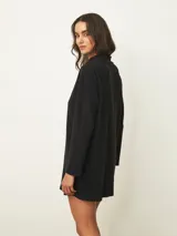 Vestido corto de cuello alto y manga larga, confeccionado en tejido de punto suave con un corte recto y holgado.