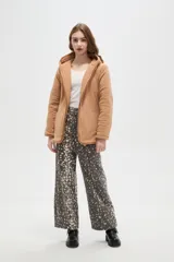 Campera de diseño capitoneado con cierre frontal, capucha integrada y bolsillos laterales. Presenta un corte entallado y mangas largas.