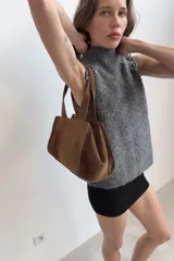 Top sin mangas de punto con mezcla de lana y alpaca, color gris jaspeado. Presenta cuello subido y detalle de abalorios joya en los hombros.