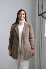Blazer de corte recto con estampado de cuadros tipo príncipe de gales en tonos marrones y beige. Presenta solapas clásicas, bolsillos frontales aplicados y mangas largas.