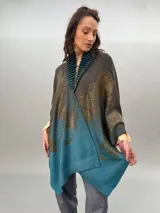 Ruana de lana merino tejida, teñida y estampada, con cuello plisado en fieltro de lana merino.