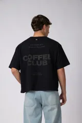 Remera boxy de algodón color marrón, de mangas corta y calce holgado, con estampa sutil con la leyenda 'COFFEE' en el pecho.
