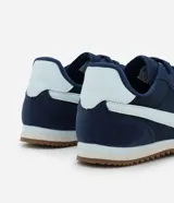 Championes estilo vintage runner color azul marino, con detalles laterales en color celeste claro y suela de goma dentada en tono marrón.