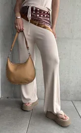 Pantalón acampanado color beige de tejido de punto acanalado.