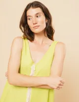 Vestido largo blanco de lino con escote en V y flecos de algodón en los bordes.