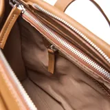 Cartera tipo tote de cuero color suela, con doble asa de hombro y correa larga ajustable y extraíble. Presenta un diseño minimalista con el logo de la marca grabado en el centro.