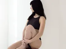 Top negro confeccionado en lycra y tela de malla semitransparente, con diseño de cuello halter y ajuste posterior.