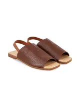 Sandalia plana de cuero graneado color marrón chocolate, con tira elástica en el talón, punta cuadrada y suela baja.