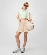 Short pollera deportivo de microfibra color beige, con diseño plisado y cintura elastizada con cordón regulable.