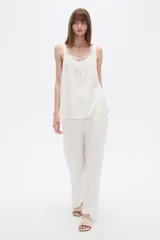 Musculosa blanca de viscosa con breteles anchos, cuello en V y detalle de lazo frontal.