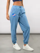 Pantalón de piqué recto color azul marino, con cintura elástica y cordón ajustable. Presenta el escudo del Club Nacional de Football en el muslo izquierdo y el logo de Umbro en el muslo derecho.