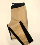 Pantalón de corte recto, confeccionado con frente de cuerina elástica color tostado y parte trasera de gabardina negra. Posee cintura elástica.
