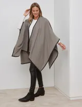 Ruana de tejido suave color azul oscuro, con vivos de ecocuero negro en los bordes.