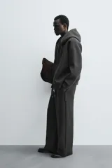 Pantalón de corte wide fit confeccionado en tejido técnico con efecto neopreno. Presenta cintura elástica ajustable con cordón, perneras anchas con costura frontal, bolsillos laterales y bolsillos traseros de plastrón.