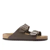 Sandalias Birkenstock modelo Arizona con dos correas ajustables con hebillas metálicas. Presentan una plantilla anatómica de corcho y ante, con suela de EVA y material superior Birko-Flor en color marrón oscuro.