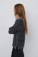 Buzo de tejido de punto en color azul con diseño geométrico texturizado, cuello redondo y mangas largas.