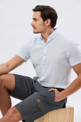 Bermuda cargo de gabardina en color gris oscuro, corte recto, con bolsillos laterales con solapa y cierre de botones y cremallera.