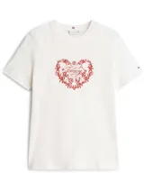 Remera de algodón de corte regular, color blanco, con cuello redondo y mangas cortas. Presenta un estampado frontal en color rojo que combina un diseño floral en forma de corazón con el logo de la marca en el centro. Incluye el logo de la marca bordado en la manga.
